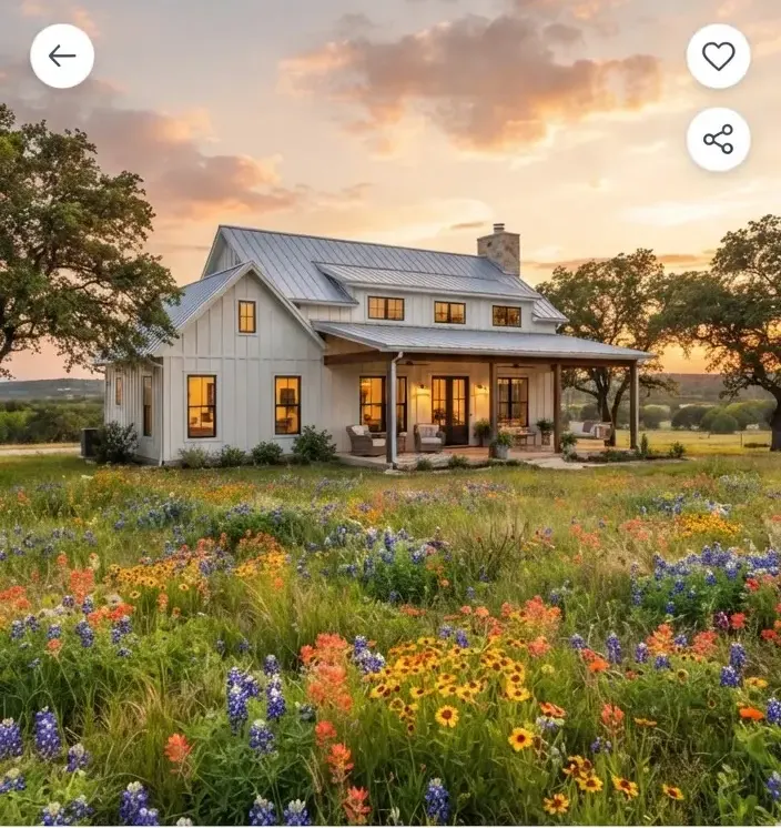 A contemporary farmhouse residence bordered by expansive open wildflower meadows in Buda Texas during late spring.