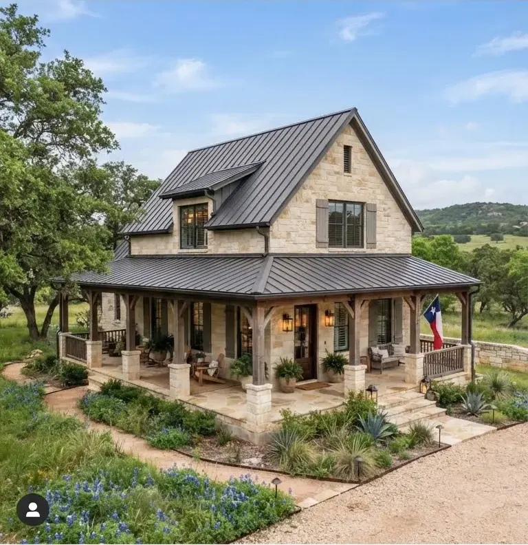 A contemporary German Sunday house-inspired farmhouse in Fredericksburg, Texas, with heavy ashlar limestone walls, standing seam metal roof, and…