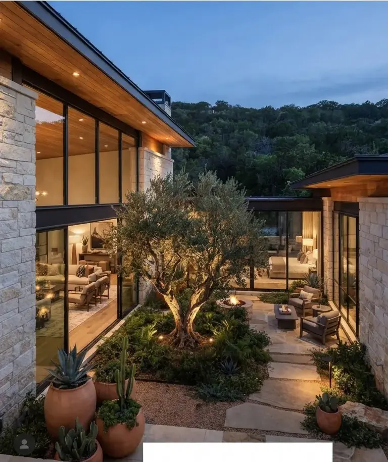 Architectural courtyard estate adjacent to Austin Barton Creek Greenbelt, crafted with native Texas cream limestone, expansive glass walls looking…