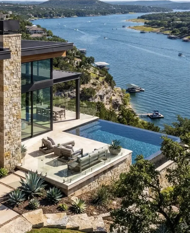 Deep blue waters of Lake Travis at Lakeway Texas with luxury cliffside modern villa overlooking panoramic hillside shores.