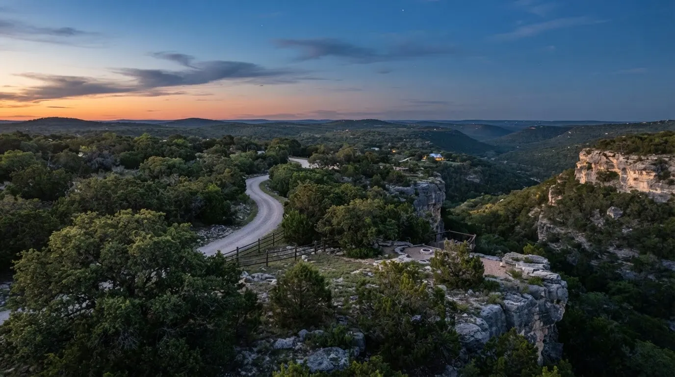 Secluded 15 acre Wimberley parcel with dense live oak canopies, limestone ledge features, and deep limestone canyon views at twilight.