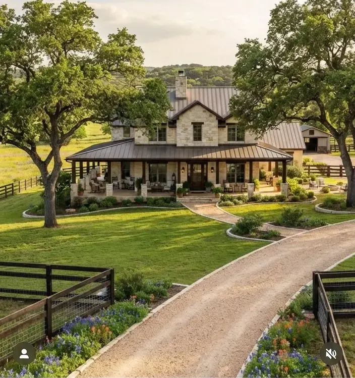 Luxury pastoral ranch home on Creek Road in Dripping Springs featuring sprawling wrap-around porches, live oak shade trees, limestone driveway,…